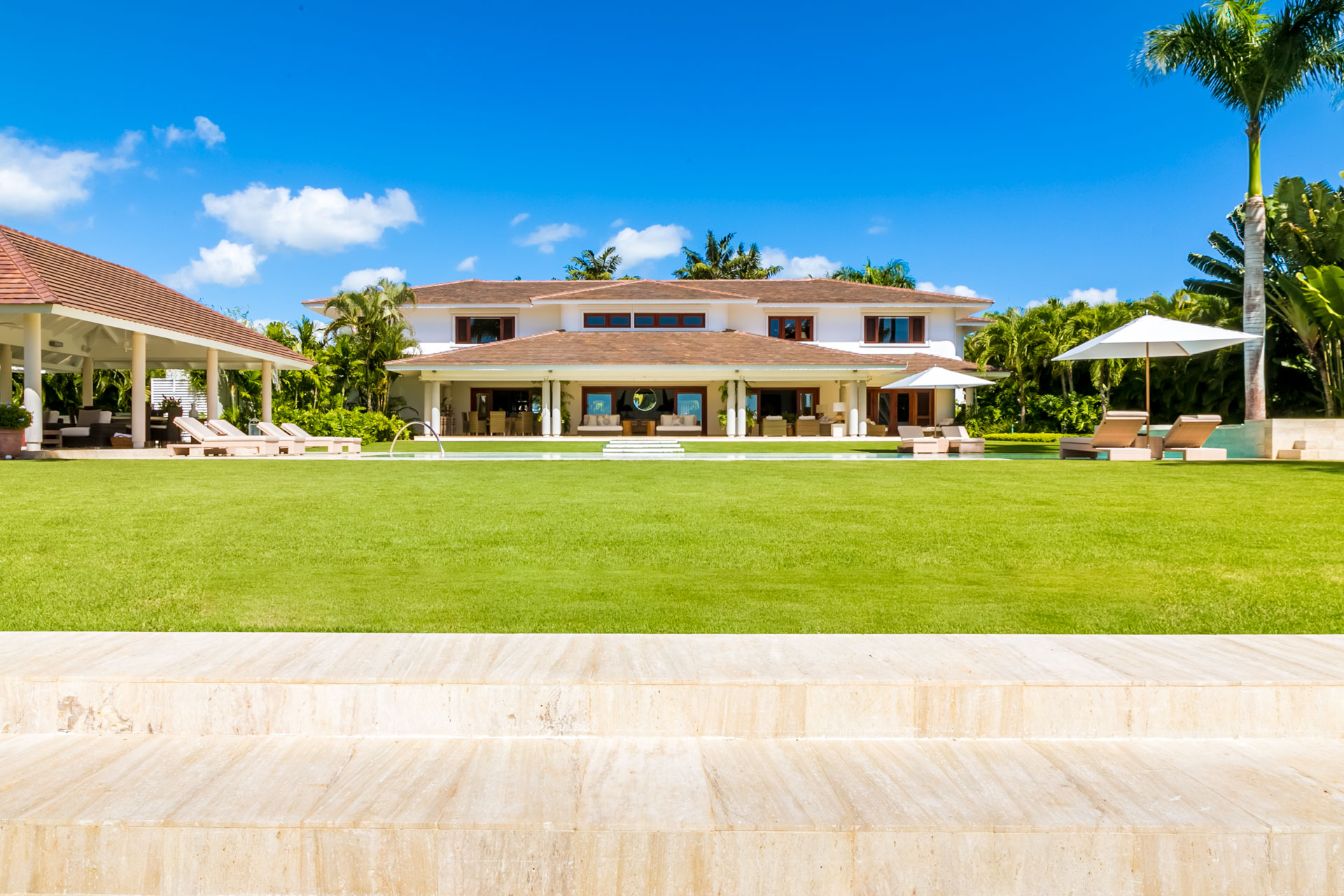 Lawn and pool terrace at a Riomar villa — Casa de Campo® Resort, Dominican Republic