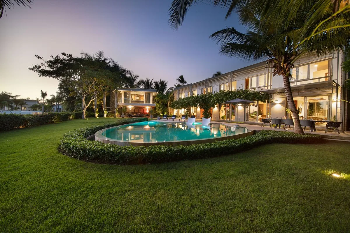 Villa and curved pool at dusk across the lawn, Barranca 17, Barranca, Casa de Campo®