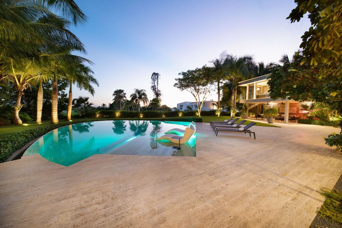 Freeform pool and travertine deck at sunset, Barranca 17, Barranca, Casa de Campo®