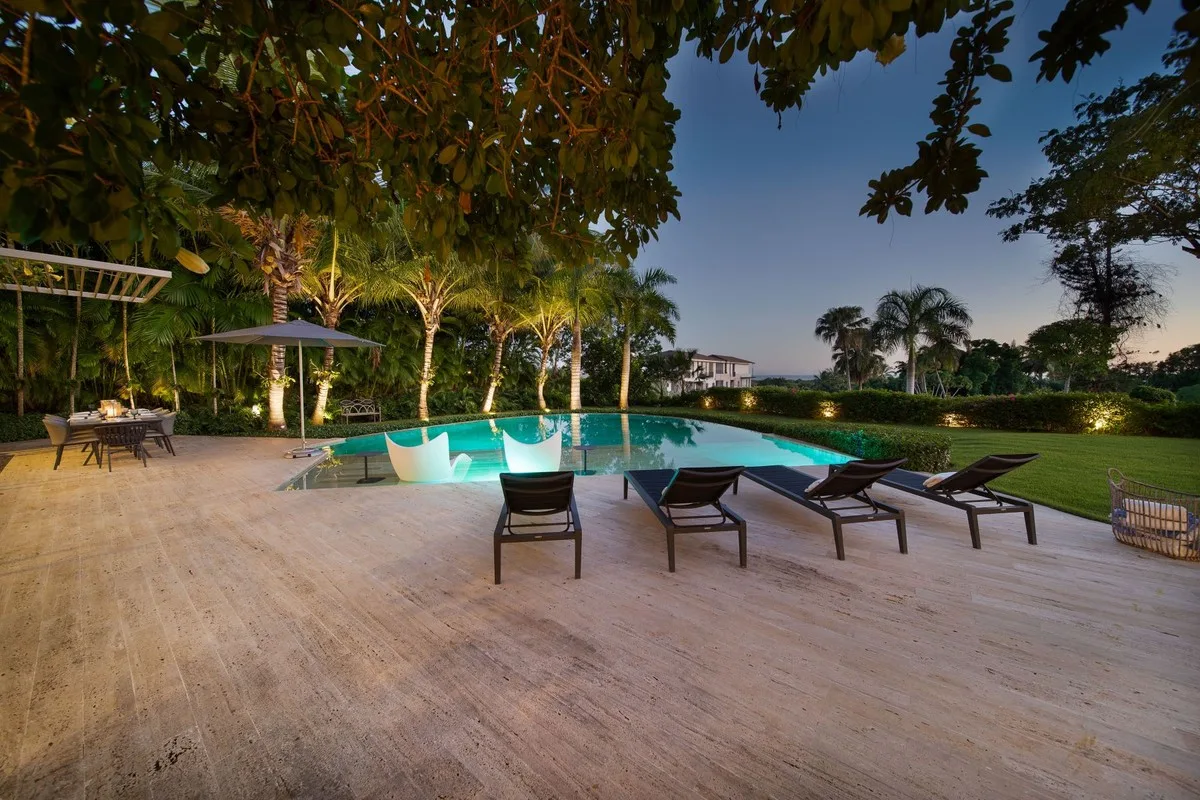Pool deck with sun loungers under mature trees at dusk, Barranca 17, Barranca, Casa de Campo®