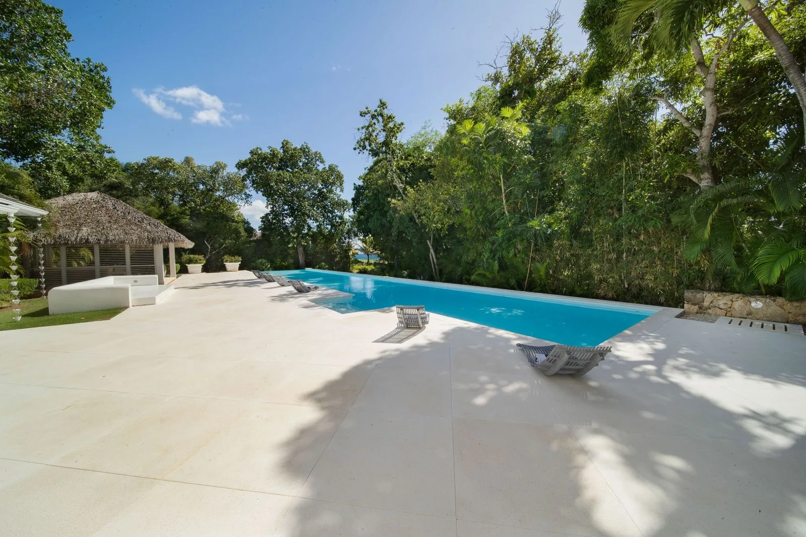 Infinity-edge pool and deck framed by tropical trees, Cacique 26, Cacique, Casa de Campo®