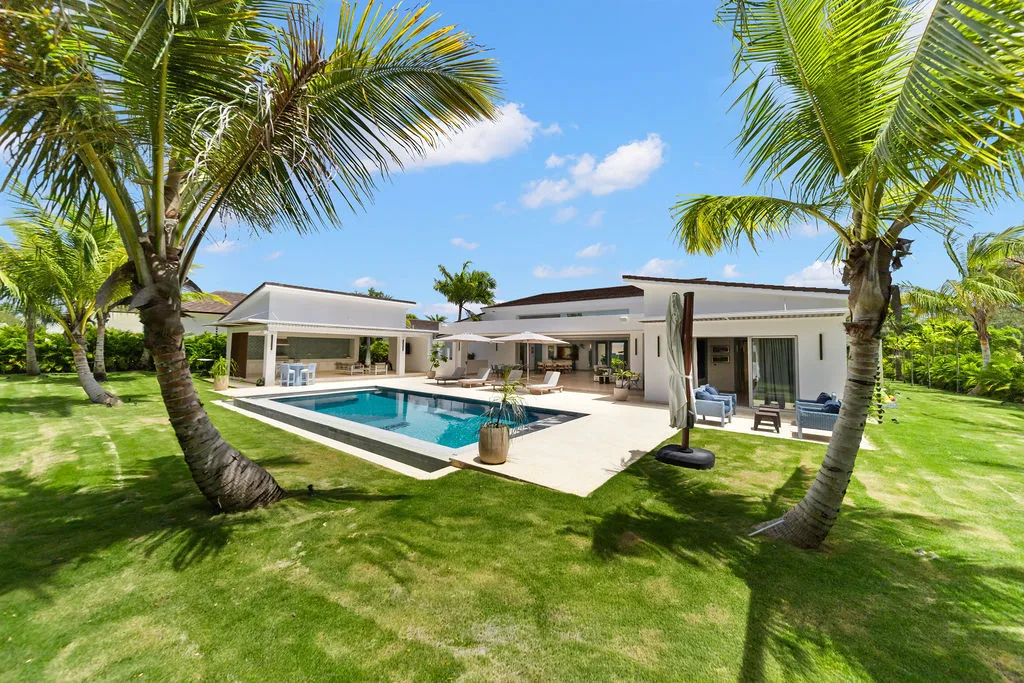 Single-level villa and pool across a palm-studded lawn, La Vereda 26, La Vereda, Casa de Campo®